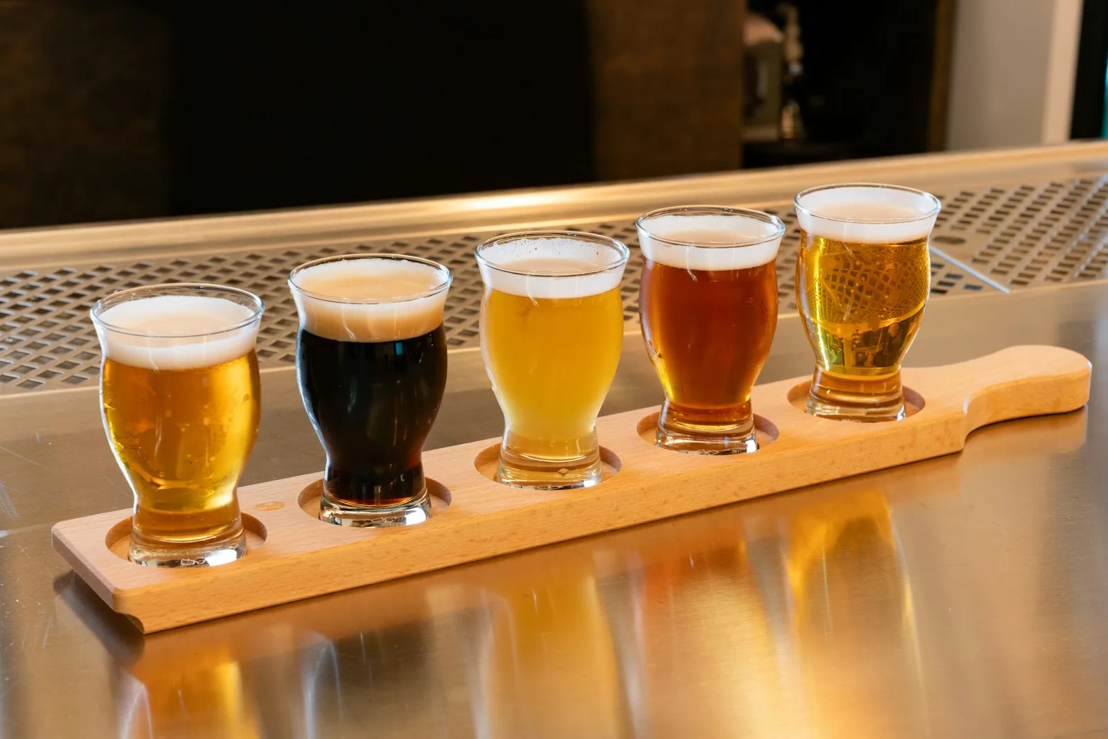 Dois copos de cerveja artesanal Amber Ale servidos em ambiente de degustação ao lado de petiscos