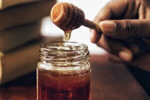 Cerveja Weissbier sendo servida em um copo alto com espuma cremosa e fundo desfocado