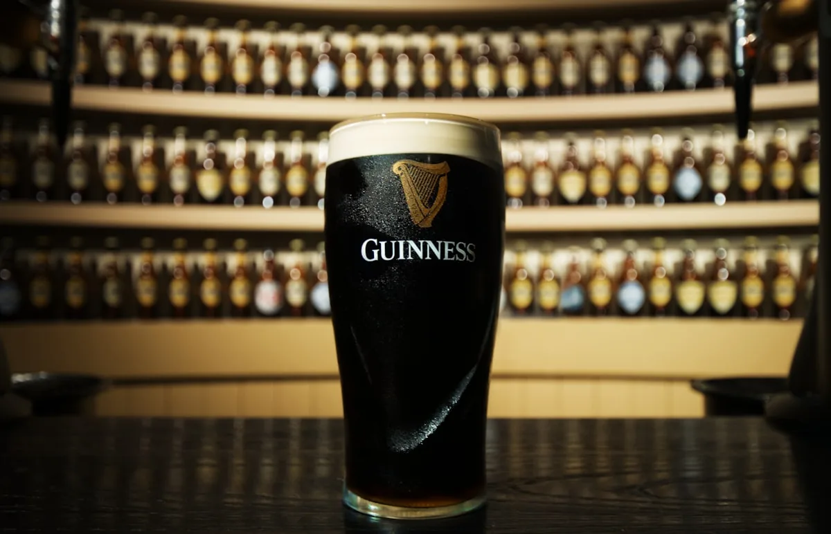Cerveja Stout sendo servida em um copo pint — técnica de servir com espuma cremosa perfeita