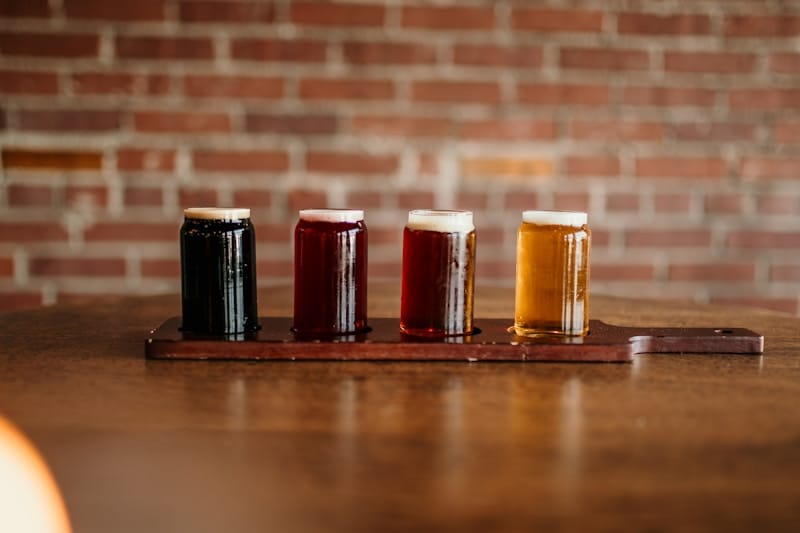 Diferentes tipos de cerveja stout servidas em copos — Dry Stout, Milk Stout e Imperial Stout lado a lado